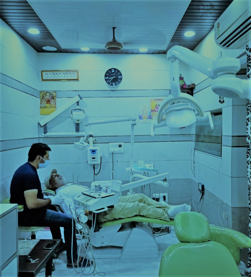 a patient being treated by a young indian male dental expert at bhatia dental clinic ludhiana