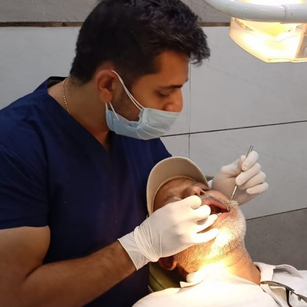 a patient being treated by an indian male dentist at bhatia dental clinic ludhiana